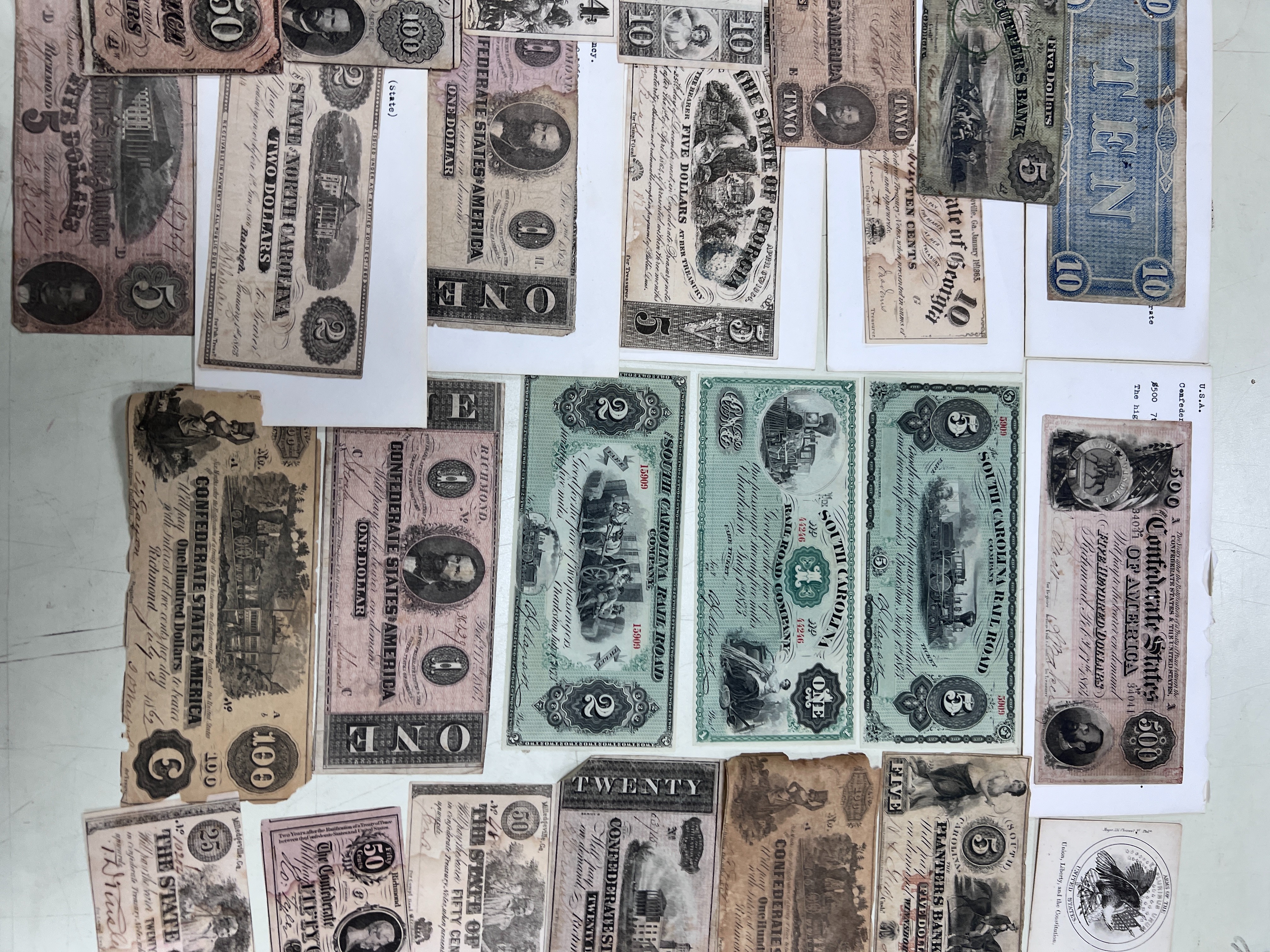 A collection of US Confederate States banknotes, including a confederate states of America $500 seventh issue 17 February 1864, $100 Richmond July 4 1862 x 2 and another 1864, and many others